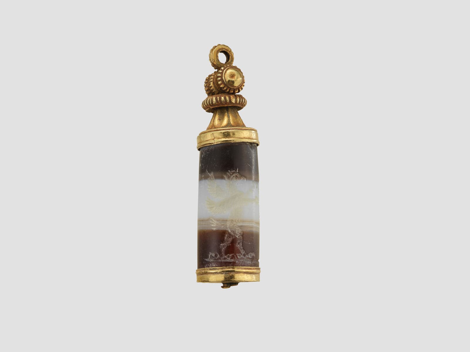 Small carved onyx cylinder seal and its rolled-out impression, showing figures in profile