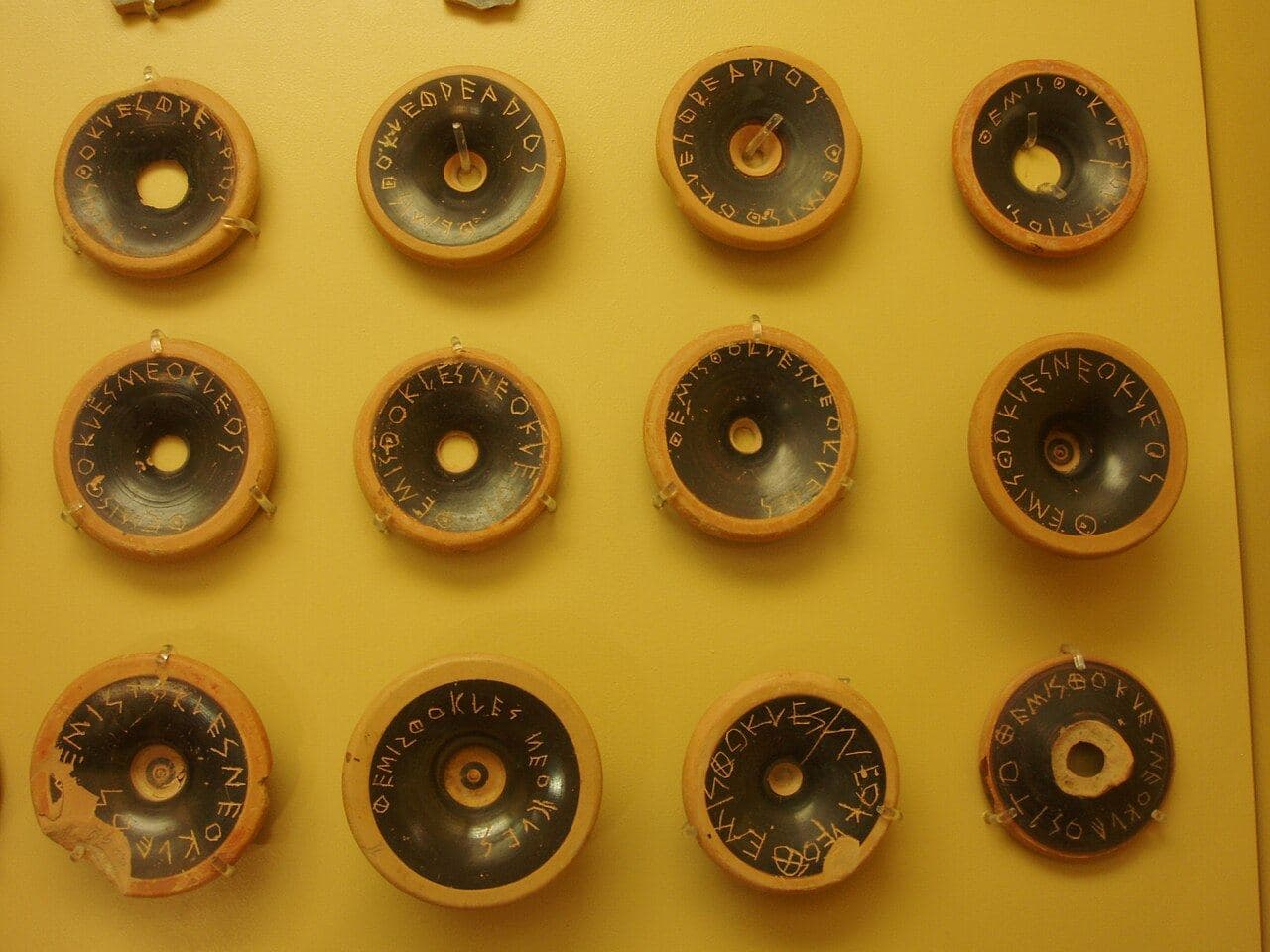Weathered black-glazed pottery fragments, each scratched with the Greek letters of Themistocles' name