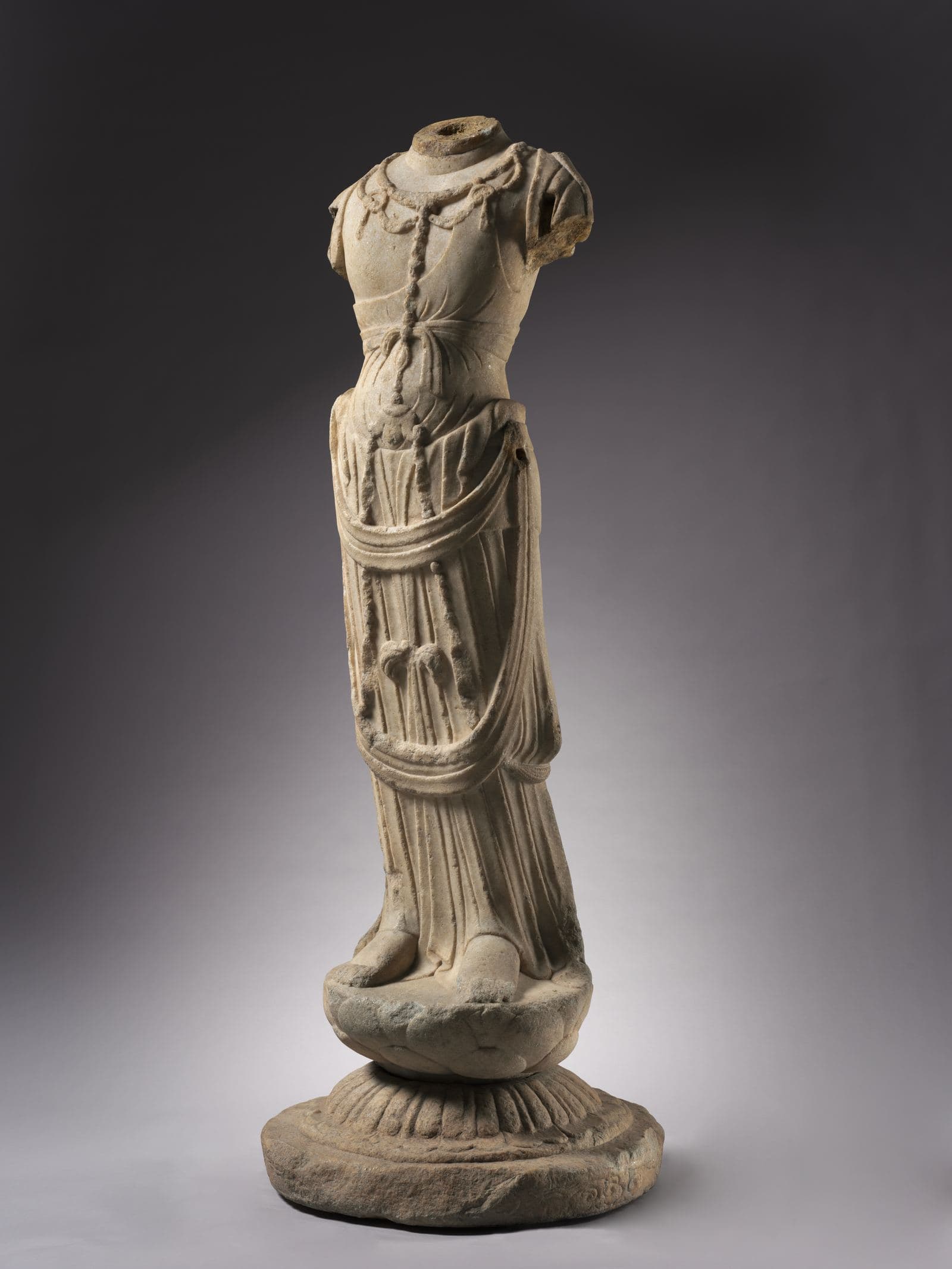 White marble torso of a bodhisattva figure with flowing, deeply carved drapery