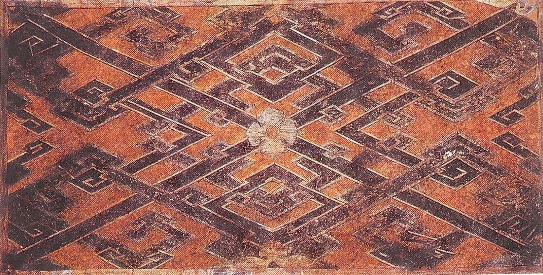 Fragment of patterned woven silk, worn and discoloured with age